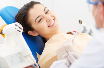 a happy smiling woman in a dentist chair