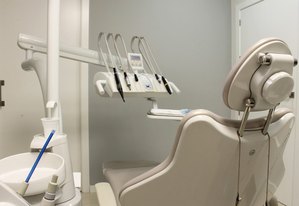 a photo of a dentist station with chair and dental instruments in a room