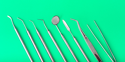 Eight silver dentist tools sit on a bright green background