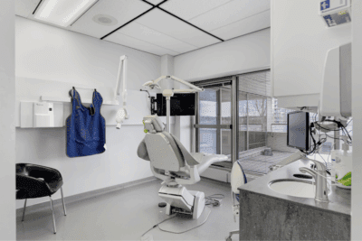 A dentist 's office with an open door to the bathroom.