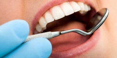 A person is holding a tooth brush in their mouth.