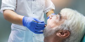 A man getting his teeth checked by an eye doctor.